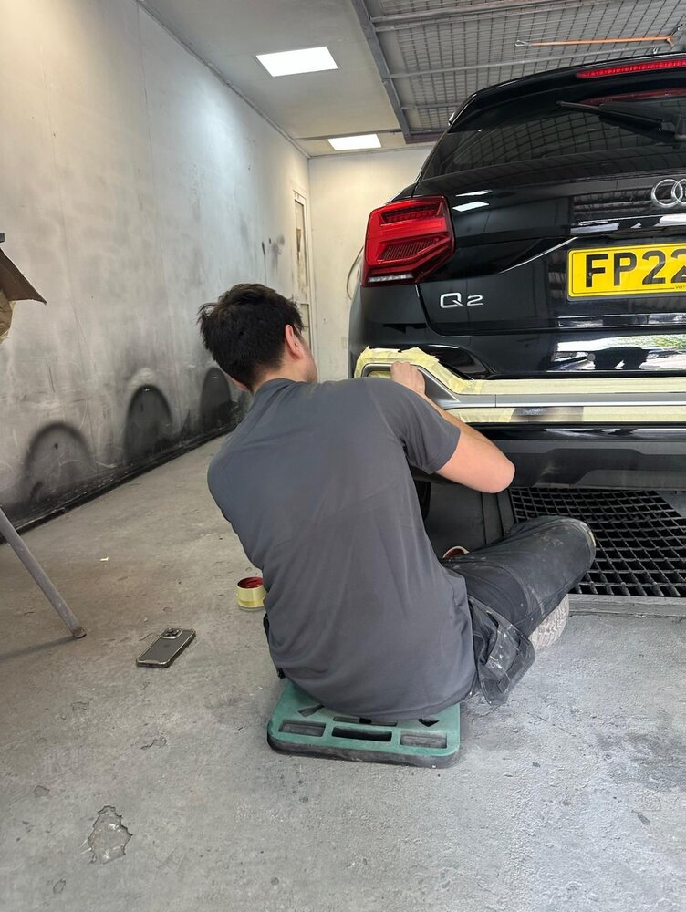 A trainee sitting and working in the garage